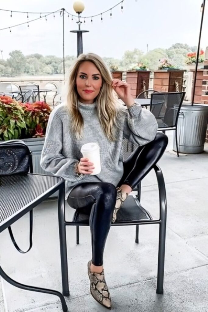 model wearing oversized grey sweater as a tunic over faux leather leggings