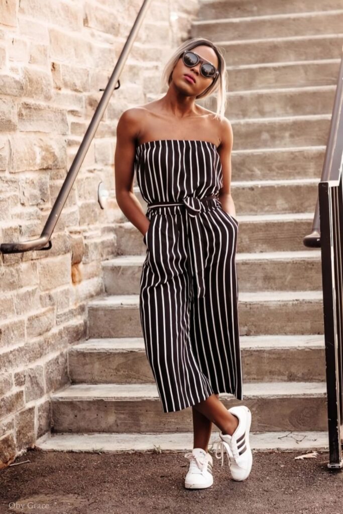 woman in black and white striped romper and white sneakers