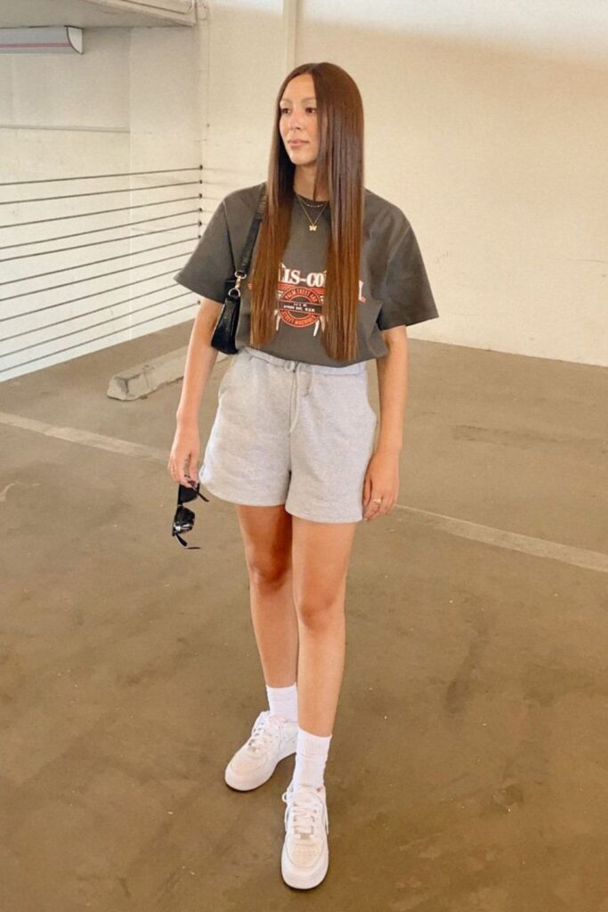 woman in high-waisted shorts, graphic tee, and sneakers