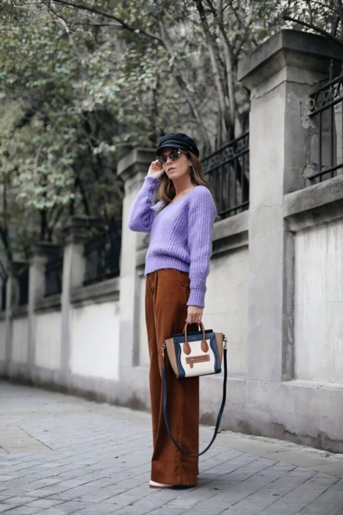 woman wearing an oversized lavender sweater with brown corduroys and white sneakers