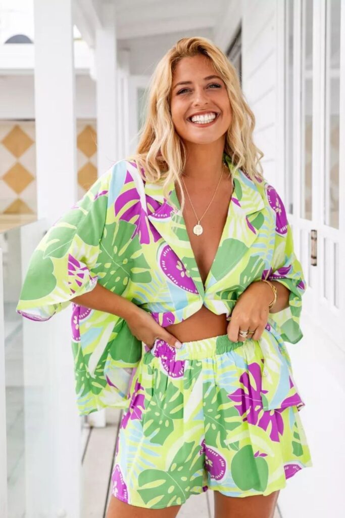 a woman wearing a tropical print crop top and matching shorts 