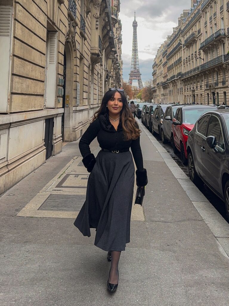 Black fur-collar cardigan with a charcoal full midi skirt, faux-fur cuffs, tights and heels near the Eiffel Tower