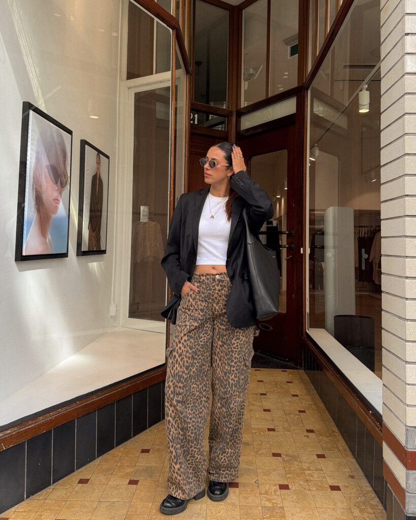 Black blazer over a white crop tee with leopard-print cargo pants, loafers and a black tote in Amsterdam