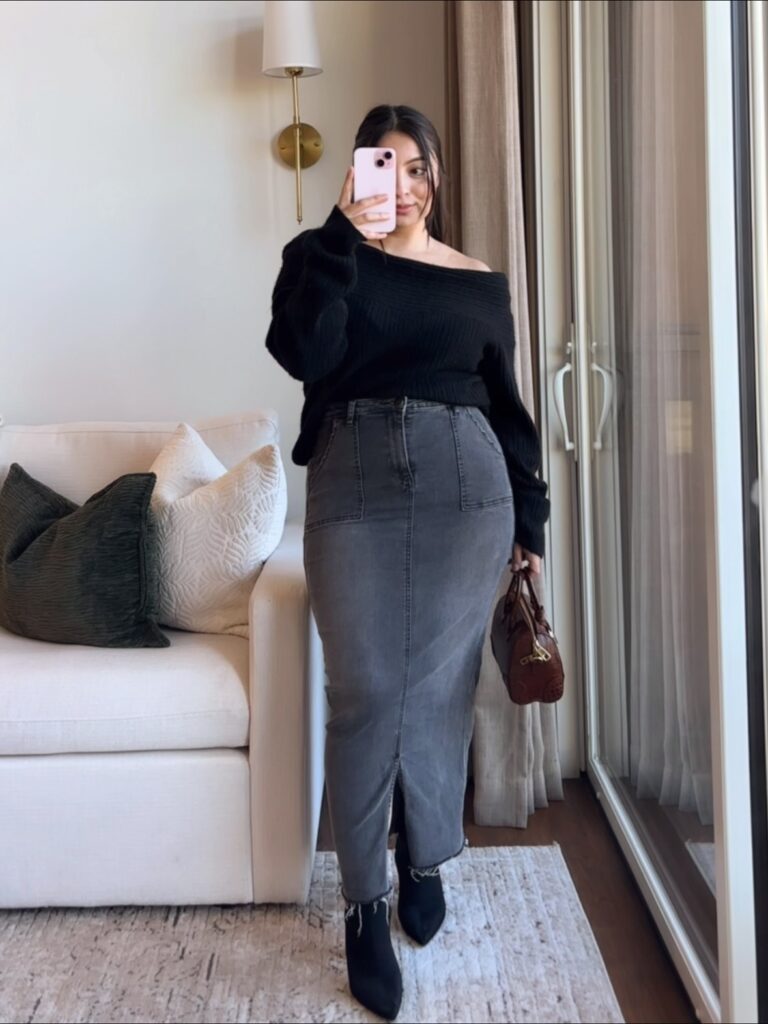 Black off-shoulder knit sweater with a long grey denim skirt, black pointed boots and a brown bag