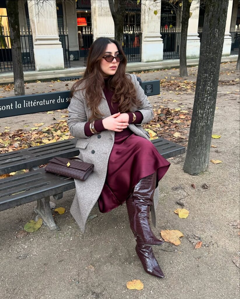 Grey wool coat over a burgundy knit and matching burgundy satin midi skirt with croc-embossed knee-high boots