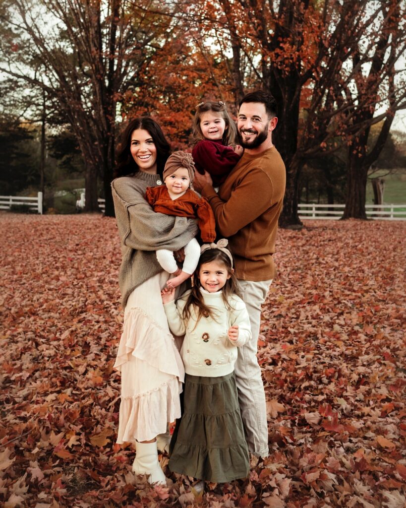 Family of five in peak fall leaves, rust and olive tones
