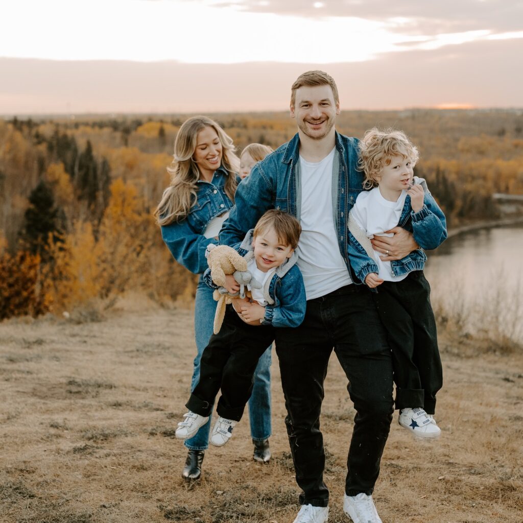 Family of four in matching denim jackets at sunset