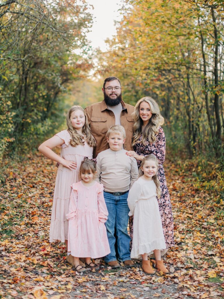 Family of six on a leafy path in soft pinks and navy floral