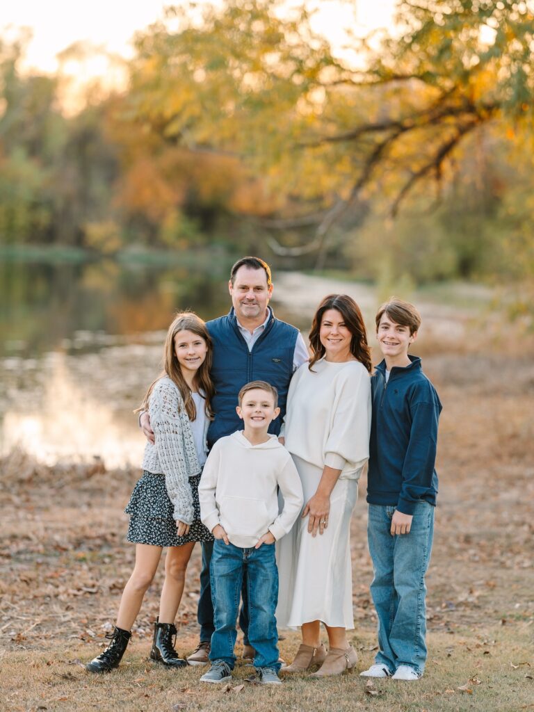 Family of five by a pond, navy vest and cream