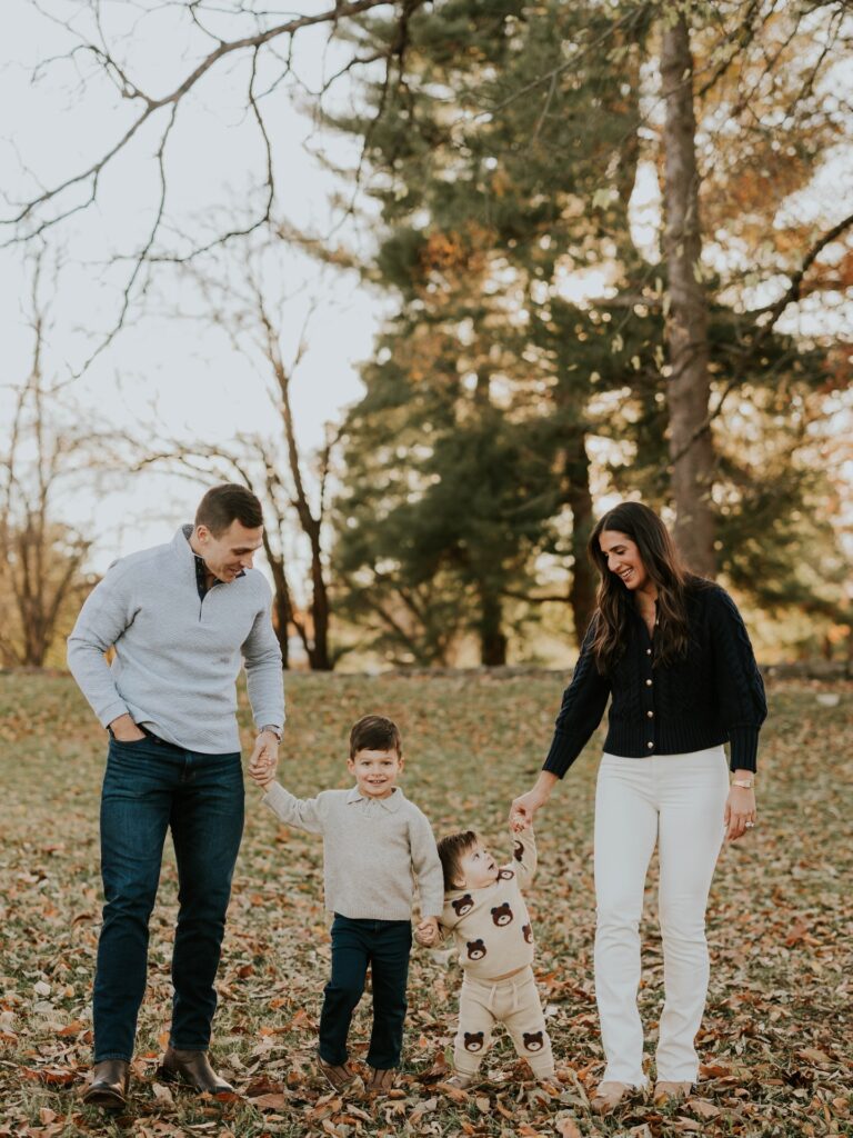 Family of four walking in leaves, navy and gray with bear sweaters