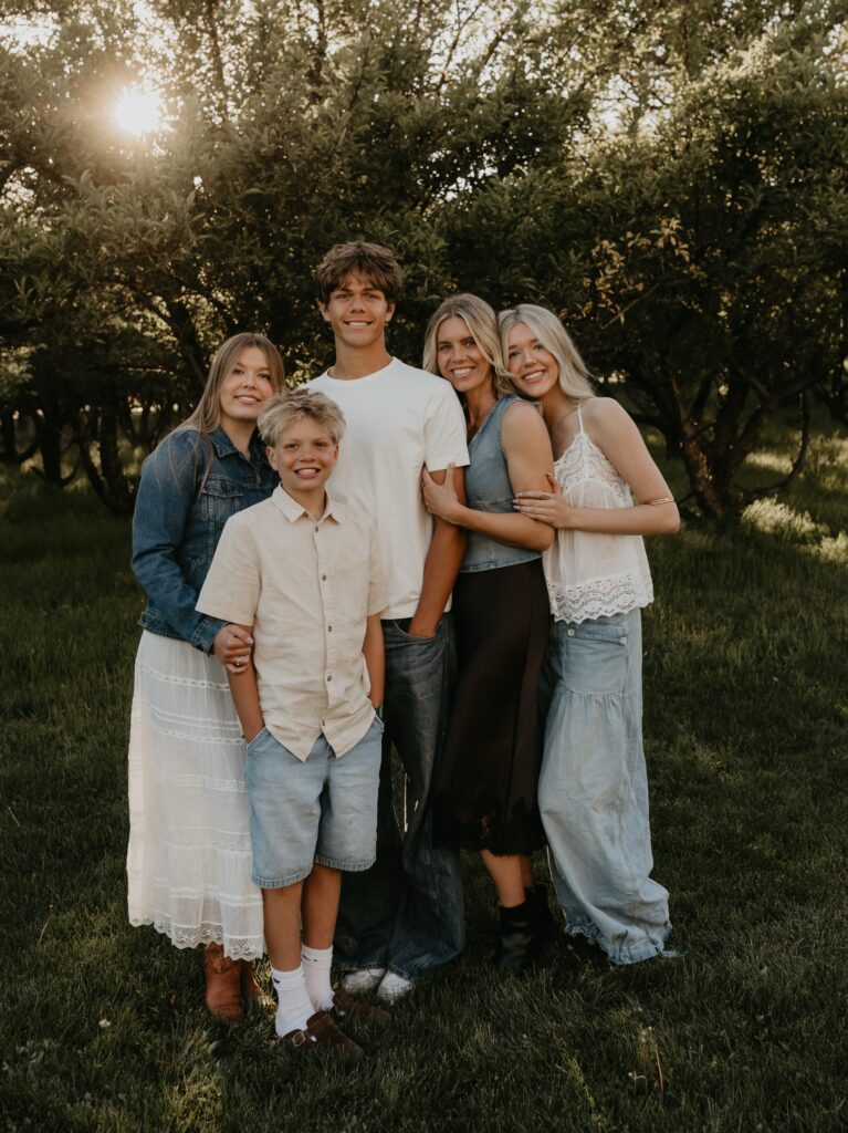 Family in cream and denim in an orchard at sunset