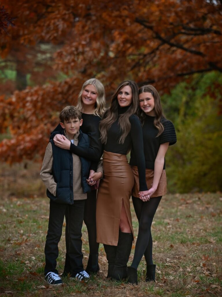Mom and teens under an autumn tree in black and camel