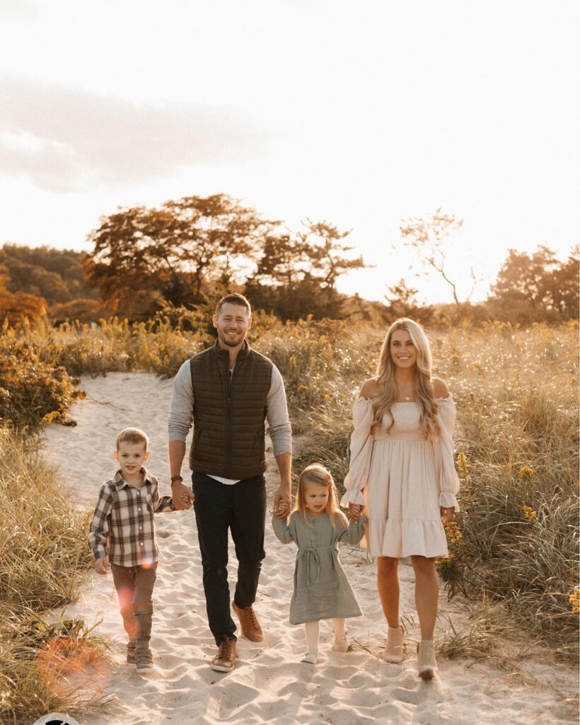 Family of four walking a dune path at sunset