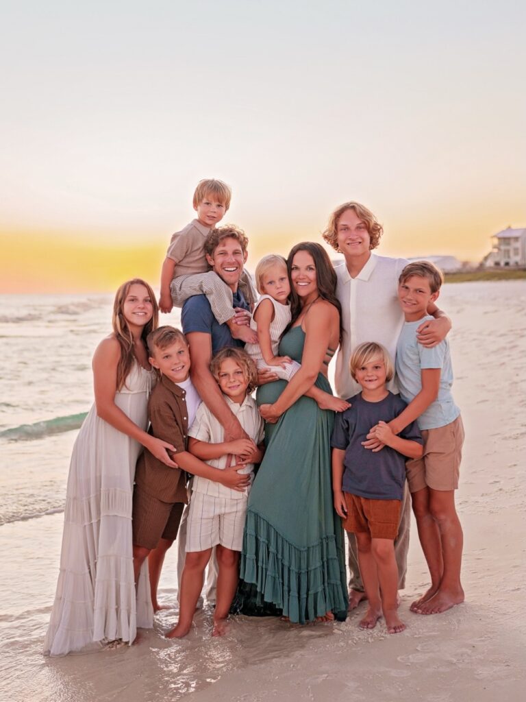 Large family on the beach in coastal earth tones at sunset